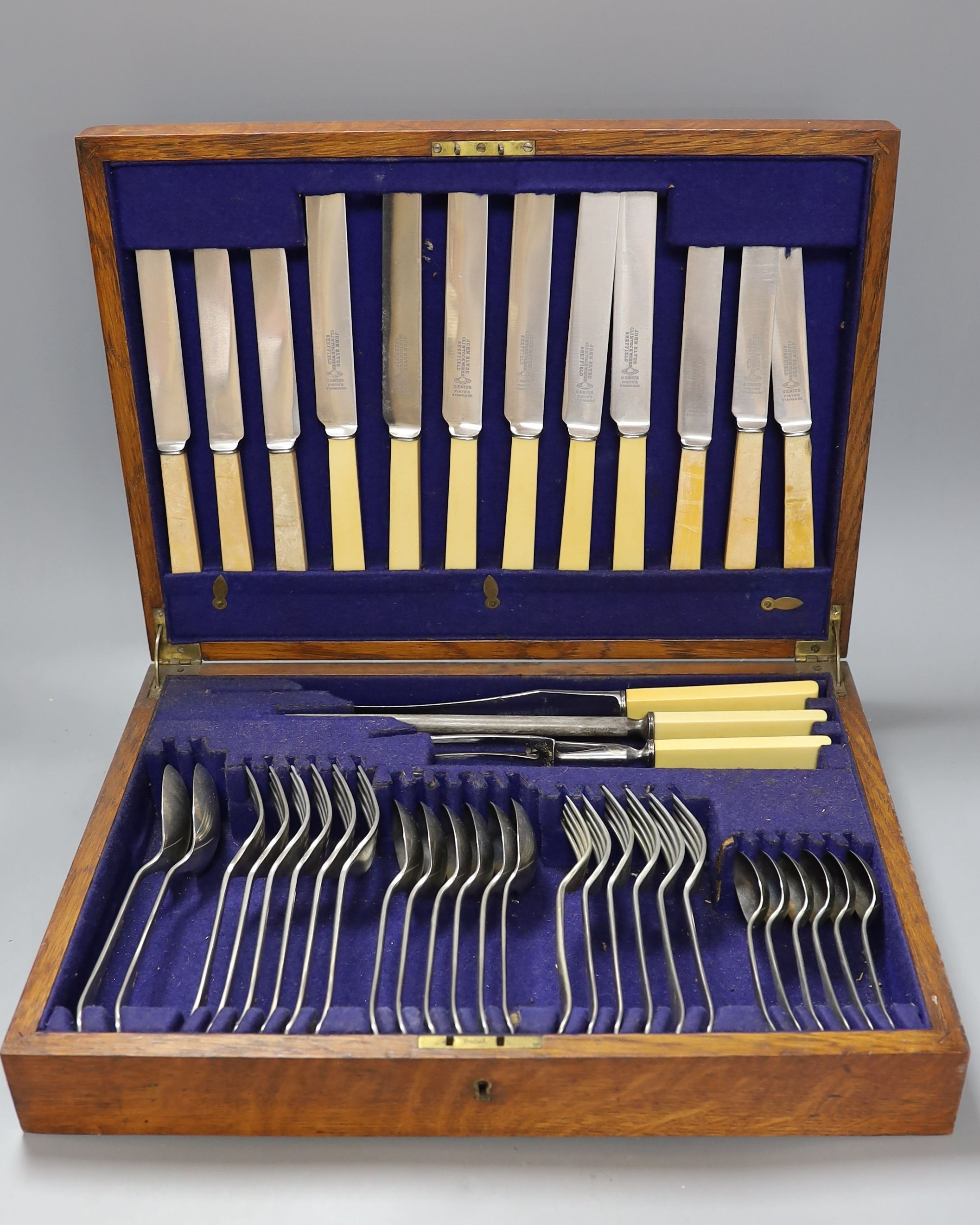 A three decanter tantalus - with labels, together with an oak canteen of table plated cutlery